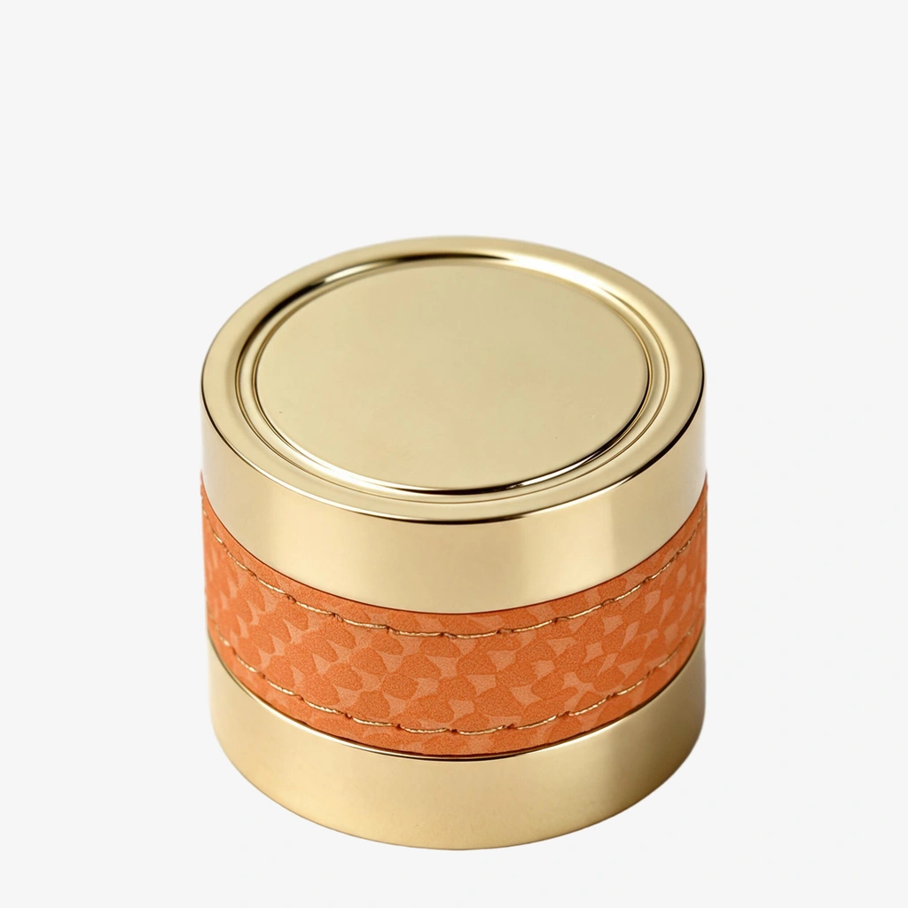 Gold perfume cap with an orange stitched leather wrap