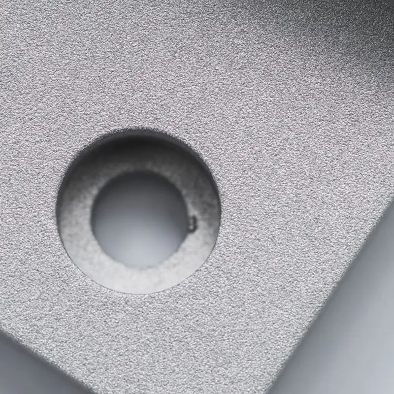 Fine-grain matte texture on a sandblasted metal part